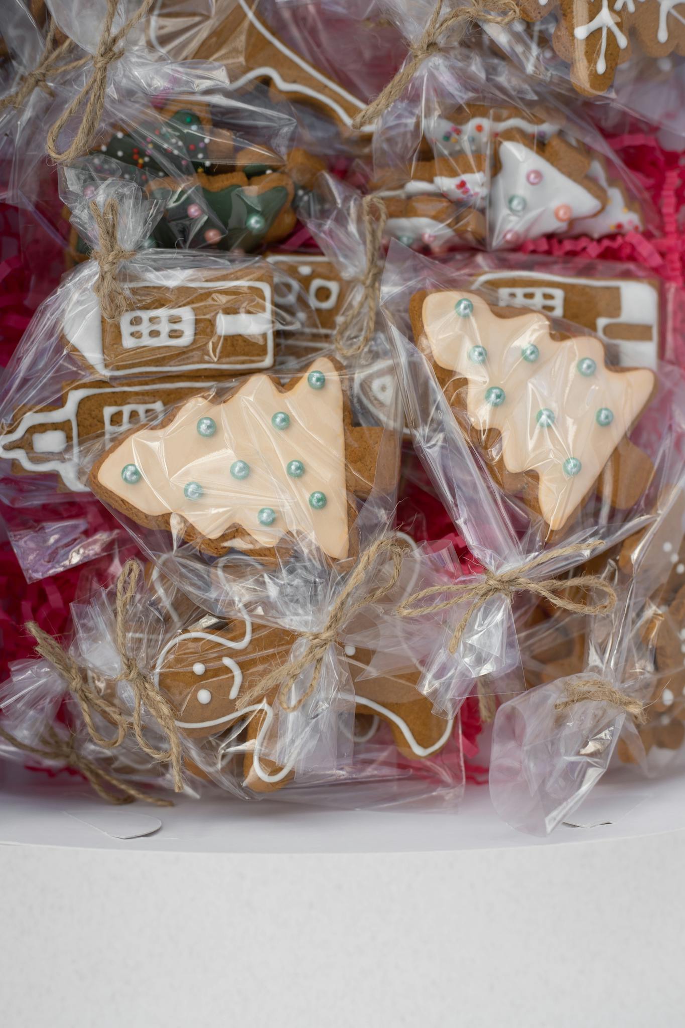 Assorted holiday-themed gingerbread cookies wrapped in plastic with festive icing decorations.