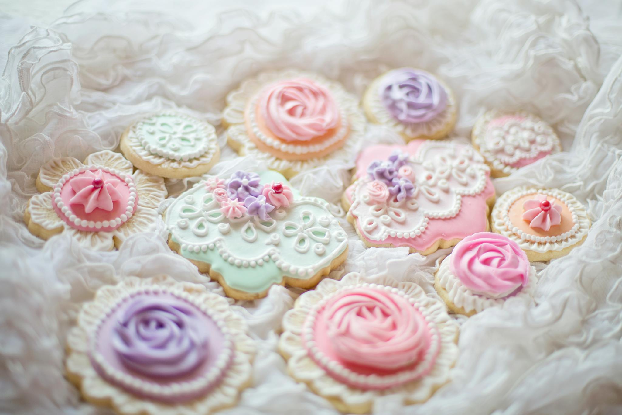 Delicate pastel decorated sugar cookies with intricate icing designs for special occasions.